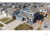 Beautiful two-story blue house with white trim, a well-manicured lawn, and a two-car garage at 540 Marmalade Dr, Berthoud, CO 80513