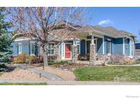Charming single-Gathering home with stone accents, covered porch, and landscaped front yard at 6263 Torrey Ln, Arvada, CO 80403