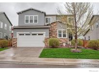 Charming two-story home featuring stone accents, a two-car garage, and well-maintained landscaping at 6935 E 133Rd Ave, Thornton, CO 80602