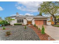 Charming single-story home with a modern wooden garage door and sleek landscaping at 7102 S Harrison Ct, Centennial, CO 80122