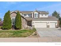 Charming two-story home featuring a three-car garage, stone accents, and professionally landscaped front yard at 11676 Montgomery Cir, Longmont, CO 80504