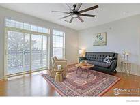 Bright living room with large windows, ceiling fan, and hardwood floors at 13456 Via Varra # 211, Broomfield, CO 80020