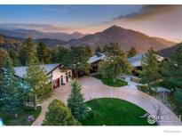 Breathtaking aerial view of an estate nestled amongst trees with mountain views at 1530 Timber Ln, Boulder, CO 80304