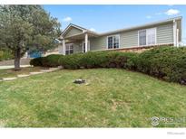Well maintained home features a spacious front yard with lush green grass and mature landscaping at 18030 E Loyola Dr, Aurora, CO 80013