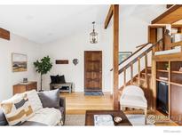 Bright living room features hardwood floors, wooden accents, and staircase with wooden railing at 279 Forrest Ln, Boulder, CO 80302