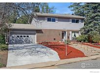 Charming two-story home featuring a brick facade, well-manicured landscaping, and attached garage at 3190 Stanford Ave, Boulder, CO 80305