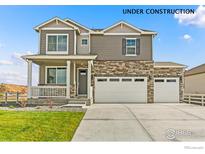 Charming two-story home with stone accents, a three-car garage, and manicured front lawn at 368 Chardon Ave, Brighton, CO 80601