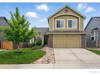 Inviting two-story home featuring a lush front yard, stone walkway, and attached two-car garage at 4774 Coker Ave, Castle Rock, CO 80104