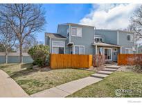 Charming two-story townhome with a well-maintained front yard, a wooden fence, and a concrete walkway at 5146 Buckingham Rd, Boulder, CO 80301
