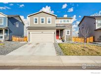 Charming two-story home with a well-maintained lawn and a two-car garage on a beautiful day at 6163 Easton Cir, Frederick, CO 80504