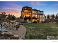 Beautiful multi-tiered backyard featuring a fire pit and spacious patio with outdoor seating and a grill at 12648 Waterside Ln, Longmont, CO 80504