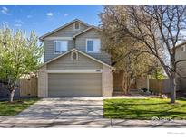 Traditional two-story home with a well-manicured lawn, mature trees, and a two-car garage at 1485 Stoneham St, Superior, CO 80027