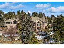 Stunning multi-level home featuring a stone facade and lush green surroundings in a peaceful and scenic neighborhood at 1682 Montane E Dr, Golden, CO 80401