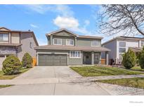 Charming two-story home boasts a well-manicured lawn, gray exterior and a convenient two-car garage at 19731 E 40Th Ave, Denver, CO 80249