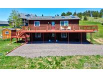 Charming two story home featuring an expansive deck and beautiful mountain views at 24057 Matterhorn Dr, Indian Hills, CO 80454