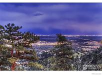 Beautiful city lights sparkle at night as seen from a mountaintop vantage point surrounded by lush trees at 36 High View Dr, Boulder, CO 80304