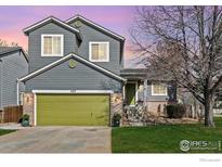 Charming two-story home with a green garage door, well-kept lawn, and inviting front entrance at 407 Simmons St, Erie, CO 80516