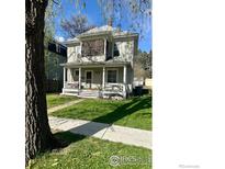 Charming two-story home featuring a covered front porch and well-maintained lawn at 525 Gay St, Longmont, CO 80501
