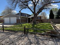 Charming home with a two-car garage, a quaint front yard, and a large tree offering shade at 647 Buchanan Ln, Longmont, CO 80504