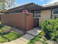 Charming front entrance featuring a pergola and a planter with vibrant flowers adding curb appeal at 6524 W 14Th Ave, Lakewood, CO 80214