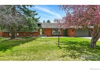Charming brick home with mature trees, a lush lawn, and a welcoming two-car garage at 6844 Roaring Fork Trl, Boulder, CO 80301