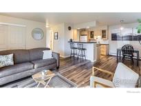 Inviting living room featuring hardwood floors, neutral walls, and an open layout with bar seating to the kitchen at 695 Manhattan Dr # 22, Boulder, CO 80303