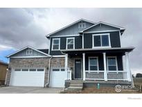 Beautiful two-story home featuring stone accents, a welcoming front porch and a two car garage at 1102 Ridgefield Dr, Berthoud, CO 80513