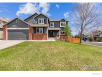 Charming two-story home with a well-manicured lawn and inviting curb appeal at 1142 Dover Way, Broomfield, CO 80020