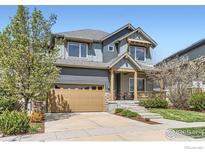 Charming two-story home featuring a manicured lawn, inviting front porch, and a two-car garage at 1833 Sweet Clover Ln, Louisville, CO 80027