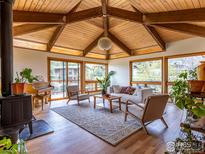 Inviting living room with vaulted wood ceilings, fireplace, and view to outdoors at 2015 Kohler Dr, Boulder, CO 80305