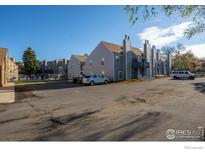 Complex featuring well-maintained grey townhomes, manicured landscaping, and convenient parking at 225 E 8Th Ave # D20, Longmont, CO 80504