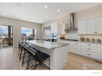 Bright, modern kitchen with white cabinets, a large island, stainless steel appliances at 3351 Heron Lakes Pkwy, Berthoud, CO 80513