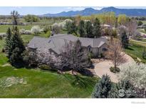 Expansive single-Gathering home with a long driveway and mature landscaping, nestled amongst flowering trees and mountain views at 5288 Waterstone Dr, Boulder, CO 80301