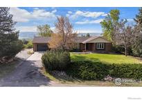 Charming brick ranch-style home with an attached two-car garage and a lush green lawn at 1198 Crestmoor Dr, Boulder, CO 80303