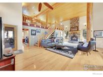 Inviting living room with stone fireplace, wood floors, vaulted ceilings, and lots of natural light at 1319 County Road 83, Boulder, CO 80302