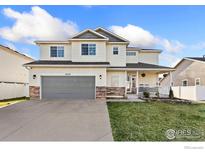 Beautiful two-story home featuring a well-kept lawn and an inviting covered front porch at 16315 9Th St, Mead, CO 80542