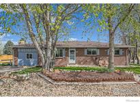 Charming single-story brick home with a well-manicured front yard and mature trees at 173 Jackson Ave, Firestone, CO 80520