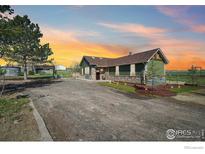 Beautiful home with green siding and stone accents and front yard at 205 S County Road 23, Berthoud, CO 80513