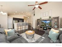 Open-concept living room featuring a modern ceiling fan, comfortable gray seating, and a view into the kitchen at 2433 Tabor St, Berthoud, CO 80513