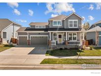 Charming two-story home with a three-car garage and covered front porch, perfect for relaxing outdoors at 338 Mt Wilson St, Brighton, CO 80601