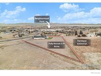 Aerial view of a fully fenced 3.79 acre lot, farmland behind, and a neighborhood pond at 3796 Vale View Ln, Mead, CO 80542