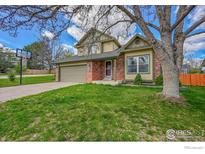 Charming two-story home with a well-maintained lawn and a basketball hoop in the driveway at 4765 S Garland St, Littleton, CO 80123