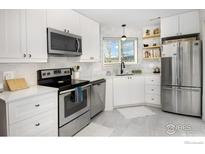 Bright kitchen with white cabinets, stainless appliances, and a window overlooking a scenic view at 4965 Twin Lakes Rd # 68, Boulder, CO 80301