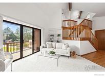 Bright living room features a sliding glass door to deck, vaulted ceilings, and open staircase at 501 Manhattan Dr # 202, Boulder, CO 80303