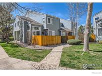 Charming two-story townhome with a well-maintained lawn, wooden fence, and inviting walkway at 5128 Buckingham Rd, Boulder, CO 80301