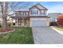 Charming two-story home with a well-manicured lawn and inviting front porch at 5894 Shenandoah Ave, Firestone, CO 80504