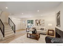 Bright living room with modern staircase, contemporary fireplace and plenty of natural light at 1496 Greenbriar Blvd, Boulder, CO 80305