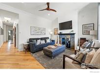 Cozy living room with a fireplace, comfortable seating, and hardwood floors creating an inviting gathering space at 2955 N Columbine St, Denver, CO 80205