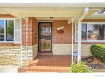 Charming brick home featuring a covered front porch with decorative ironwork and stone accents at 375 Kohl St, Broomfield, CO 80020