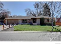 Charming single story brick home with attached garage and well-maintained front lawn at 7136 S Newland St, Littleton, CO 80128